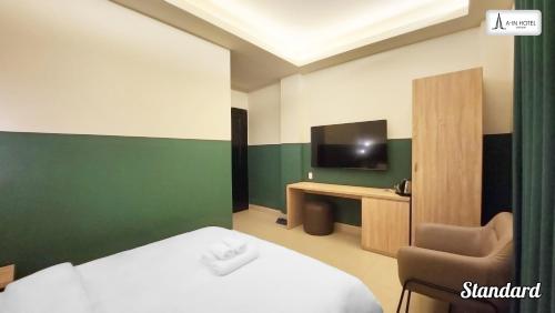 a room with a bed and a chair and a television at A In Hotel Atistar in Ho Chi Minh City