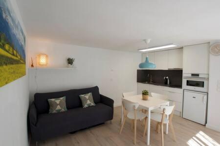 un salon avec un canapé noir et une table dans l'établissement Apartamento Galicat, à Bourg-Madame