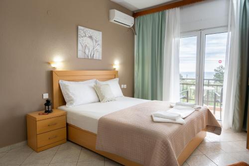 a bedroom with a bed and a large window at House Elena in Koinyra