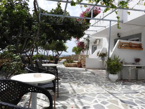 a patio with tables and chairs and plants at Studios Nina in Amoopi