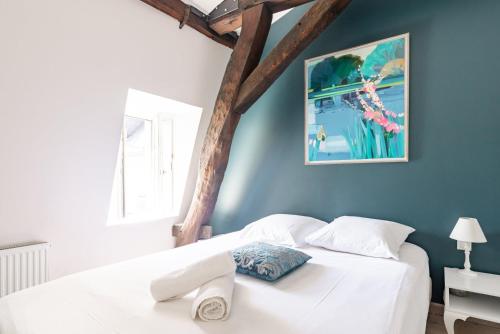 une chambre avec un lit blanc avec un mur bleu dans l'établissement 