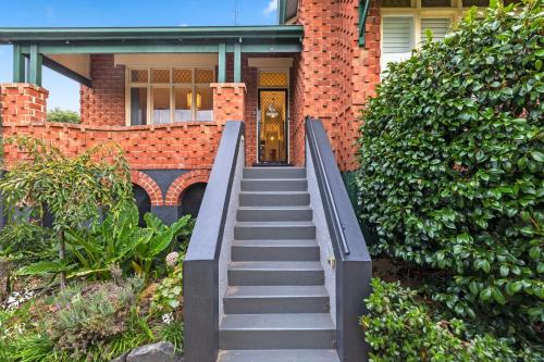 a staircase leading up to a house with a door at Mrs Percivals heritage luxury and romance with outdoor deep soak tub in Victor Harbor