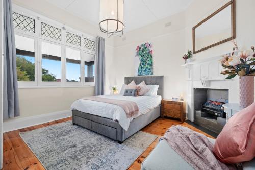 a bedroom with a bed and a fireplace at Mrs Percivals heritage luxury and romance with outdoor deep soak tub in Victor Harbor