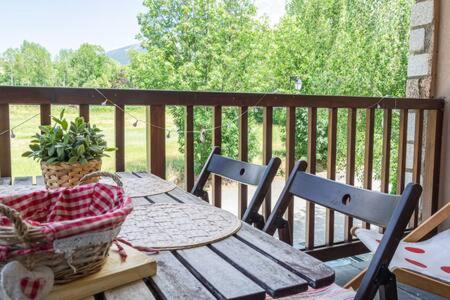 Una mesa y sillas de madera en un balcón con una mesa y una canasta. en Duplex la Solana, en Err