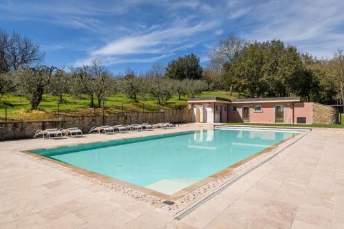 uma grande piscina com cadeiras num quintal em I Grandi Di Toscana em Ciggiano