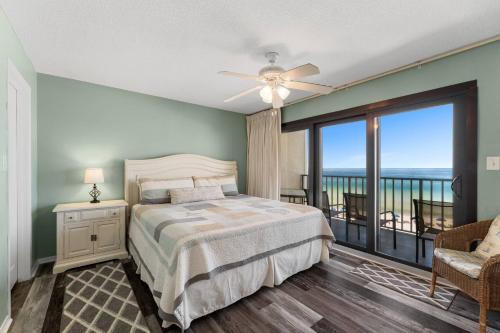 a bedroom with a bed and a balcony at Commodore 504 in Panama City Beach