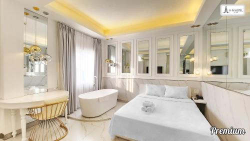 a white room with a bed and a desk at A In Hotel Atistar in Ho Chi Minh City