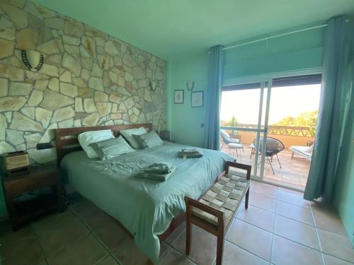 a bedroom with a bed and a stone wall at Espectacular ático dúplex con 2 terrazas & piscina in Málaga