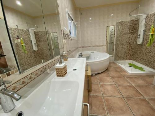 a large bathroom with a tub and a sink at Espectacular ático dúplex con 2 terrazas & piscina in Málaga