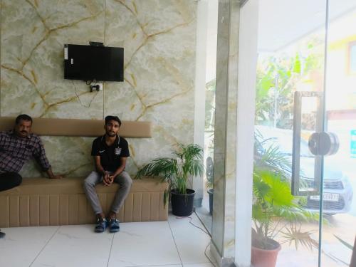 two men sitting on a bench in a building at GRACE REGENCY in Ernakulam