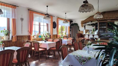 un ristorante con tavoli, sedie e finestre di Ferienwohnung Rhönwiese a Birx