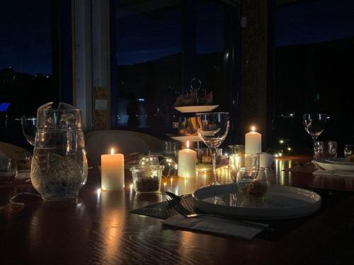 a table with candles and plates and glasses on it at Botel Diffuso dei Laghi in Porto Ceresio
