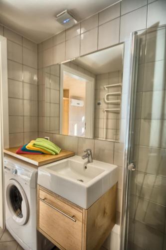 a bathroom with a sink and a washing machine at Domki KREDKA in Jastarnia