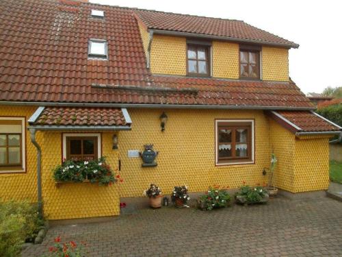 比爾克斯的住宿－Ferienwohnung Landidylle，前面有鲜花的黄色房子