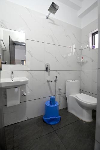 Un baño blanco con inodoro y lavabo. en Canara Vibes, en Māvalli