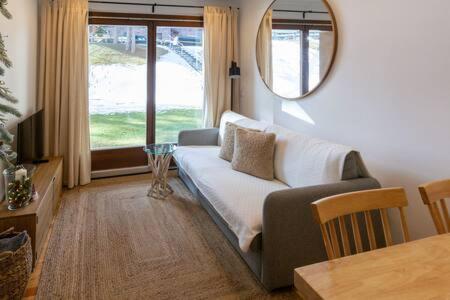 a living room with a couch and a mirror at Apartament l'Osset in La Molina
