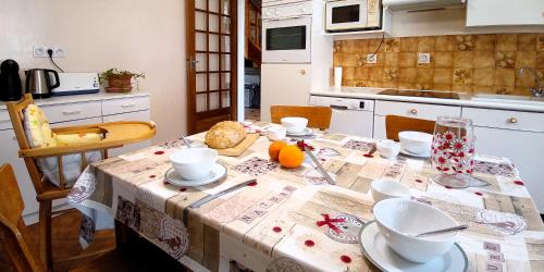a kitchen with a table with a table cloth on it at Le Petit Aigu in Clugnat