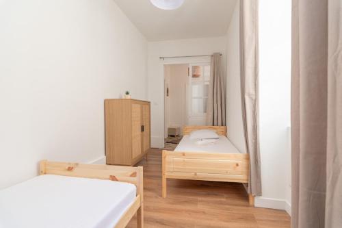 een kleine kamer met 2 bedden en een kast bij Magnifique logement spacieux hyper centre in Nuits-Saint-Georges