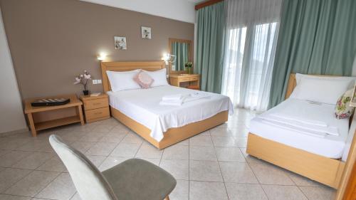 a hotel room with two beds and a chair at House Elena in Koinyra