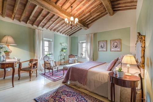 a bedroom with a bed and a table and a desk at Villa Principessa Elisa, Amazing Views, Spa & Private Pool in Capannori