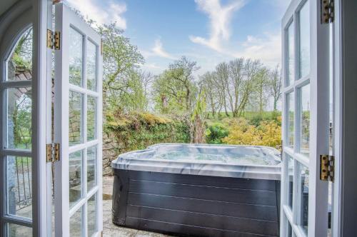 an open door with a hot tub outside at The Stables - 2 Bedroom Cottage - Princes Gate in Ludchurch