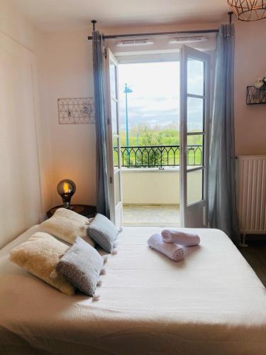 een slaapkamer met een bed en uitzicht op een balkon bij L'Escale Cosy - Disneyland Paris in Serris