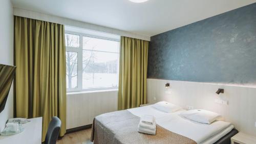 a hotel room with a bed and a large window at Viiking Spa Hotel in Pärnu