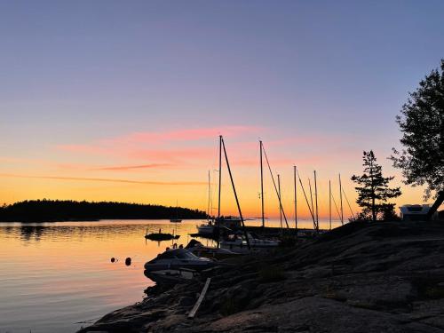 a group of boats docked on the water at sunset at Kustvy - En Destination intill Havet in Skärplinge