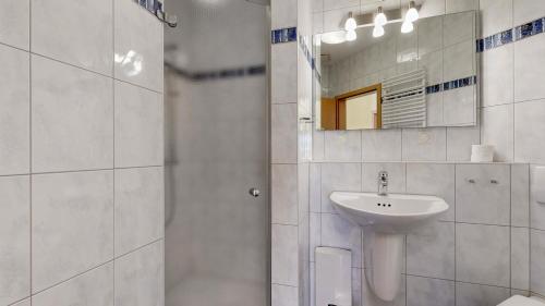 a white bathroom with a sink and a mirror at FeWo direkt am Strand mit Meerblick, Villa Strandperle, Binz in Binz