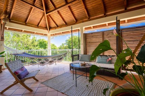 a porch with a hammock and a swing at Villa Ladouchka in Goyave