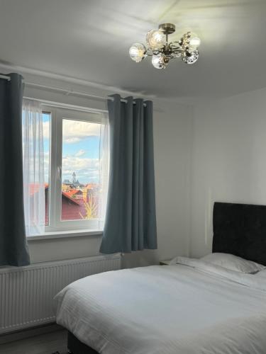 sypialnia z łóżkiem i oknem z żyrandolem w obiekcie Sunrise paradise w Suczawie