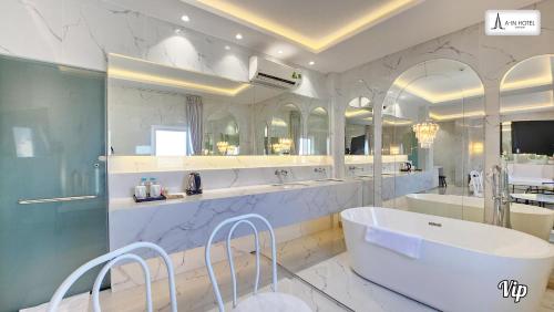 duża łazienka z wanną i dużym lustrem w obiekcie A In Hotel Atistar w Ho Chi Minh