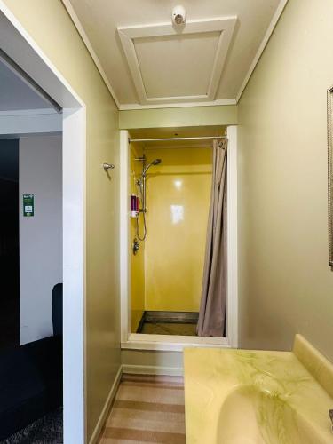 a bathroom with a shower and a sink at The Crossing Lodge & Backpackers in National Park