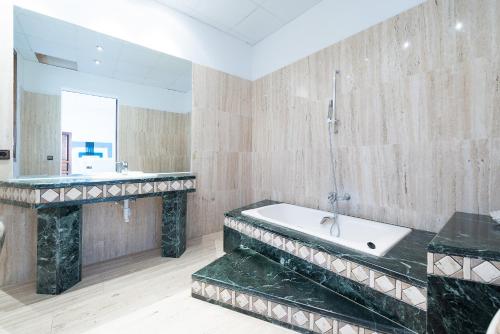 a bathroom with a bath tub and a sink at Villa Sa Verdera in Maria de la Salut