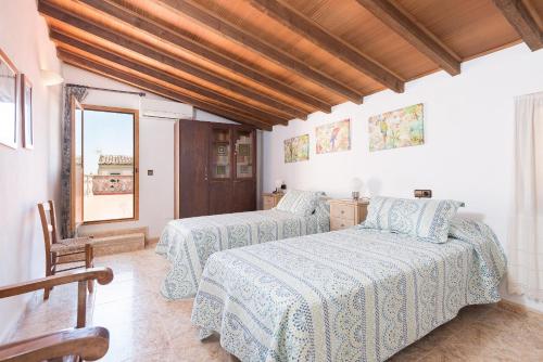 a bedroom with two beds and a window at Villa Sa Verdera in Maria de la Salut
