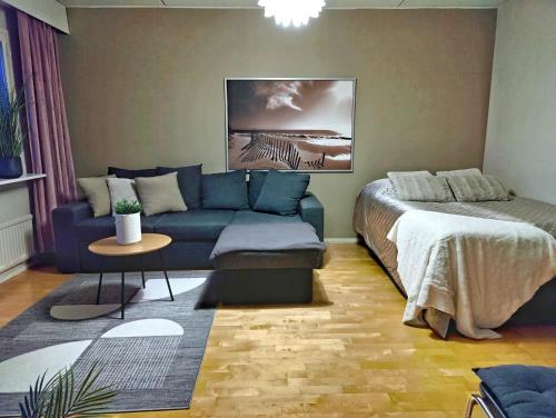 a living room with a couch and a bed at Mesikämmen - Free parking & WiFi - Next to the forest - Rating 9,4 in Jyväskylä