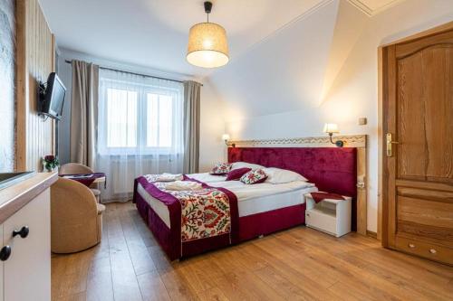 a bedroom with a bed and a large window at Pensjonat Dawidek in Zakopane