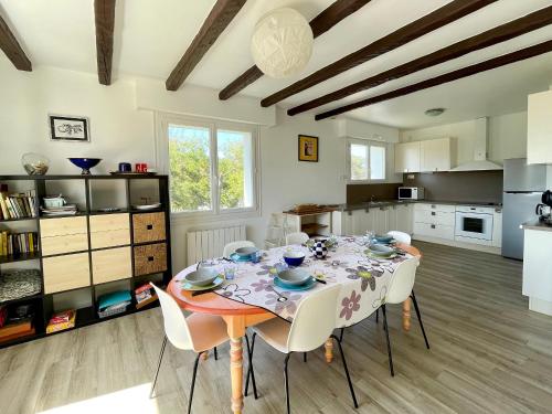 une salle à manger avec une table et des chaises dans une cuisine dans l'établissement Maison familiale au calme, proche plage, 9 couchages, terrasses, WiFi, garage vélo - Brétignolles-sur-Mer - FR-1-231-203, à Bretignolles-sur-Mer