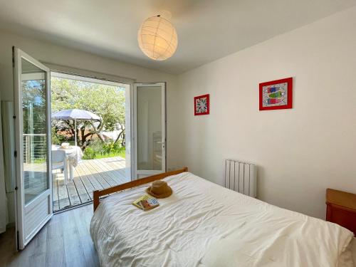 une chambre avec un lit et une porte coulissante en verre dans l'établissement Maison familiale au calme, proche plage, 9 couchages, terrasses, WiFi, garage vélo - Brétignolles-sur-Mer - FR-1-231-203, à Bretignolles-sur-Mer