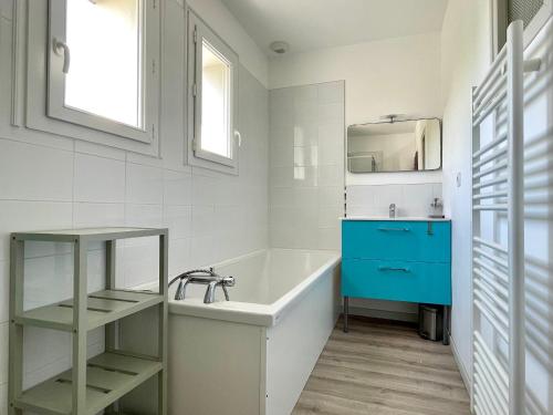 une salle de bain avec une baignoire et une armoire bleue dans l'établissement Maison familiale au calme, proche plage, 9 couchages, terrasses, WiFi, garage vélo - Brétignolles-sur-Mer - FR-1-231-203, à Bretignolles-sur-Mer