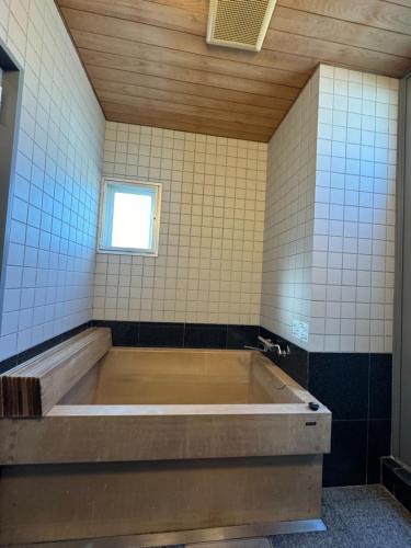 un bagno con ampia vasca e finestra di EarthVeloビル一棟貸しでフルリノベ済み各階に風呂トイレありで好立地でコスパ最高をめざしている宿です a Tokushima