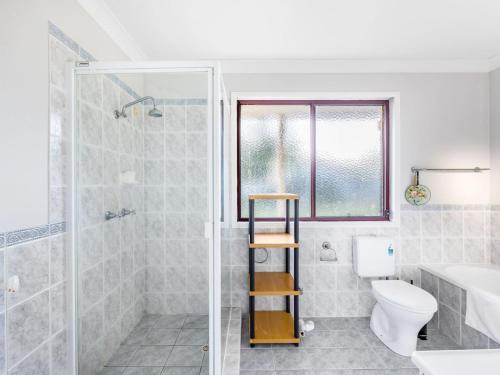 a bathroom with a shower and a toilet and a sink at Great value Stylish 2BR Granny Flat Heritage Park in Boronia Heights