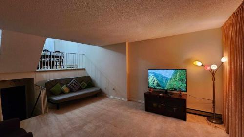 a living room with a couch and a flat screen tv at Cozy Town house in Toronto