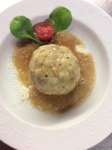 a plate of food with a dumpling on top at Sturmhof in Chiusa