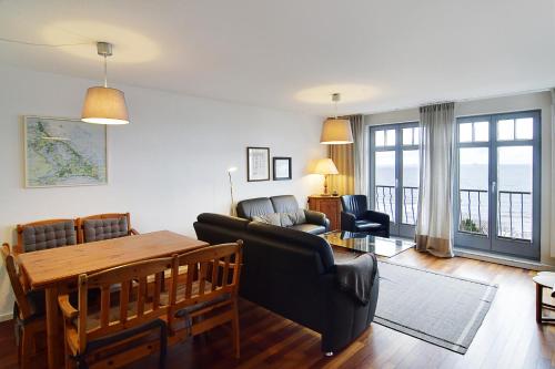 - un salon avec une table et un canapé dans l'établissement Haus-am-Kliff-App-11, à Heringsdorf