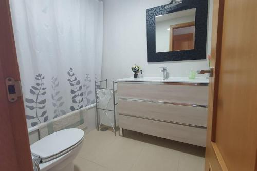 een badkamer met een toilet, een wastafel en een spiegel bij Apartamento Conil Centro y Playa, San Sebastian in Conil de la Frontera