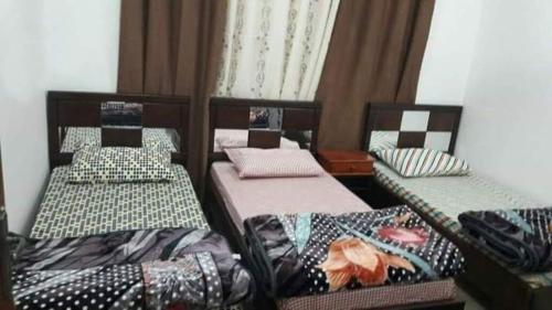 a room with three beds in a room at Jordan home in Irbid