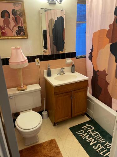 łazienka z toaletą, umywalką i zasłoną prysznicową w obiekcie H.U.S.H (Happy Your Staying Here!). Short Term Rental w mieście Oakland