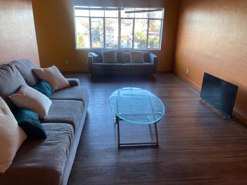 a living room with a couch and a glass table at H.U.S.H (Happy Your Staying Here!). Short Term Rental in Oakland