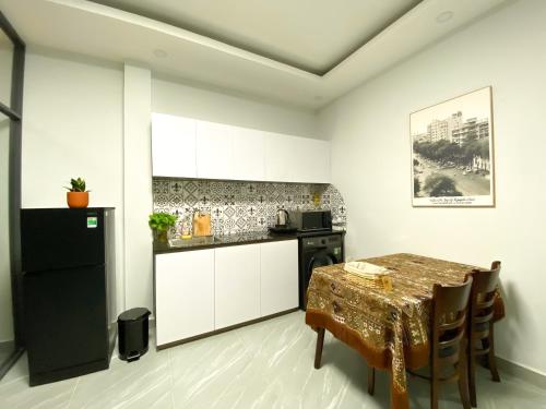 uma cozinha com uma mesa e um frigorífico preto em Calmette Home - Best Location District 1 - 500m Ben Thanh Market em Ho Chi Minh